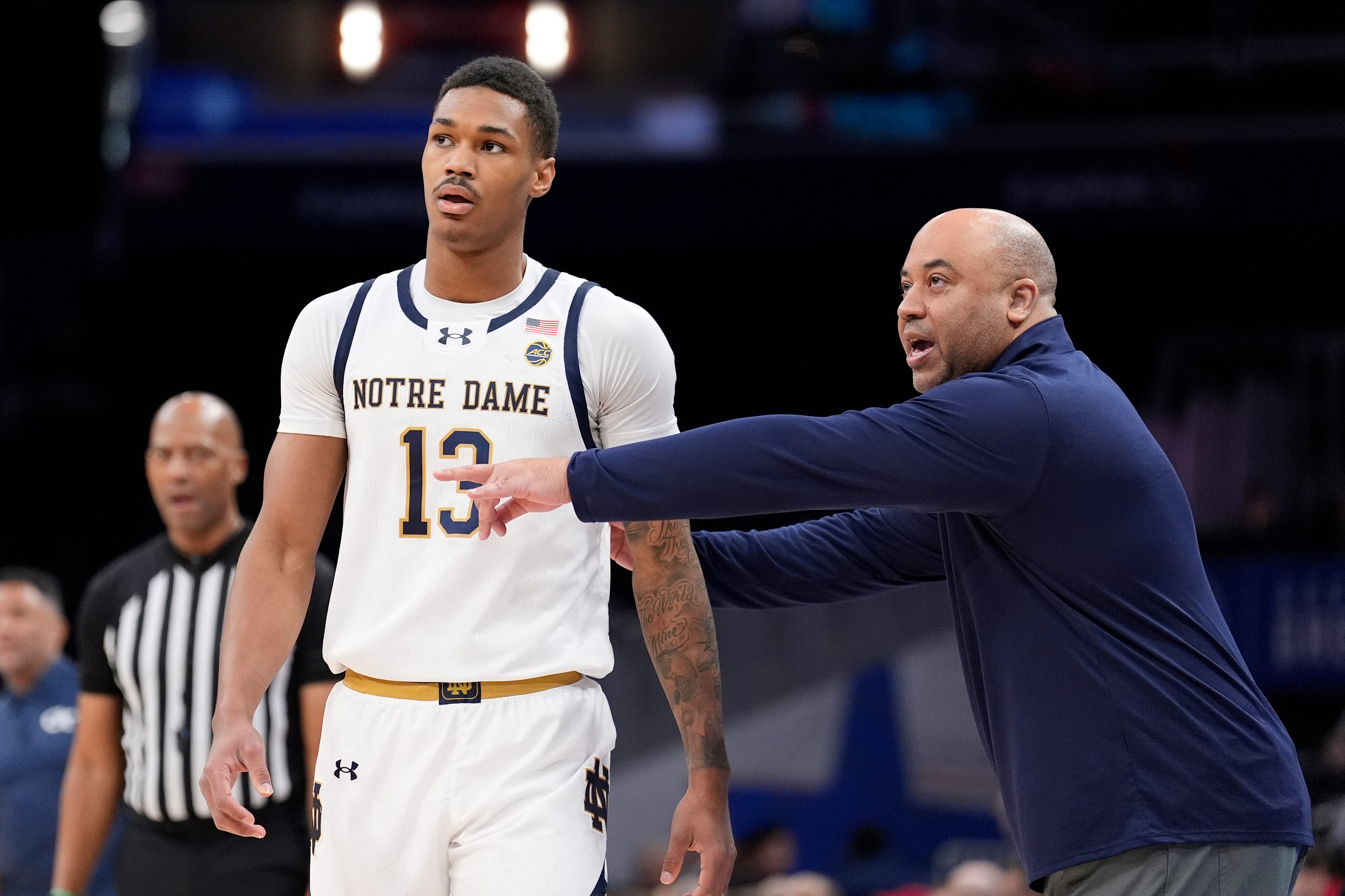 Notre Dame head coach Micah Shrewsberry, left, with Notre Dame forward Tae Davis (13) during the first half of the Atlantic Coast Conference NCAA college basketball tournament game against Georgia Tech, Tuesday, March 12, 2024, in Washington. (AP Photo/Alex Brandon)