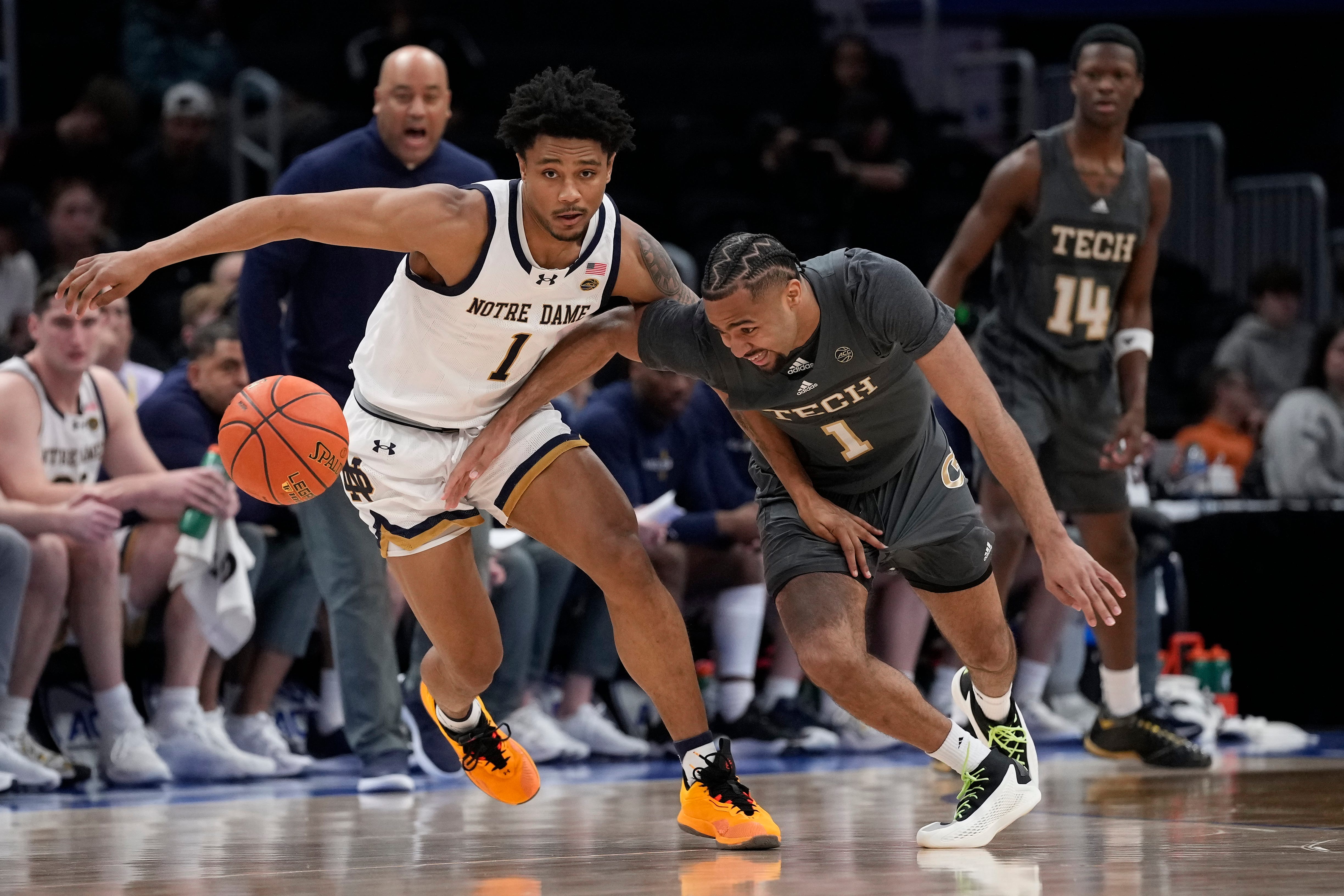Notre Dame guard Julian Roper II (1) and Georgia Tech guard Kyle Sturdivant (1) chasing a loose ball during the first half of the Atlantic Coast Conference NCAA college basketball tournament Tuesday, March 12, 2024, in Washington. (AP Photo/Susan Walsh)