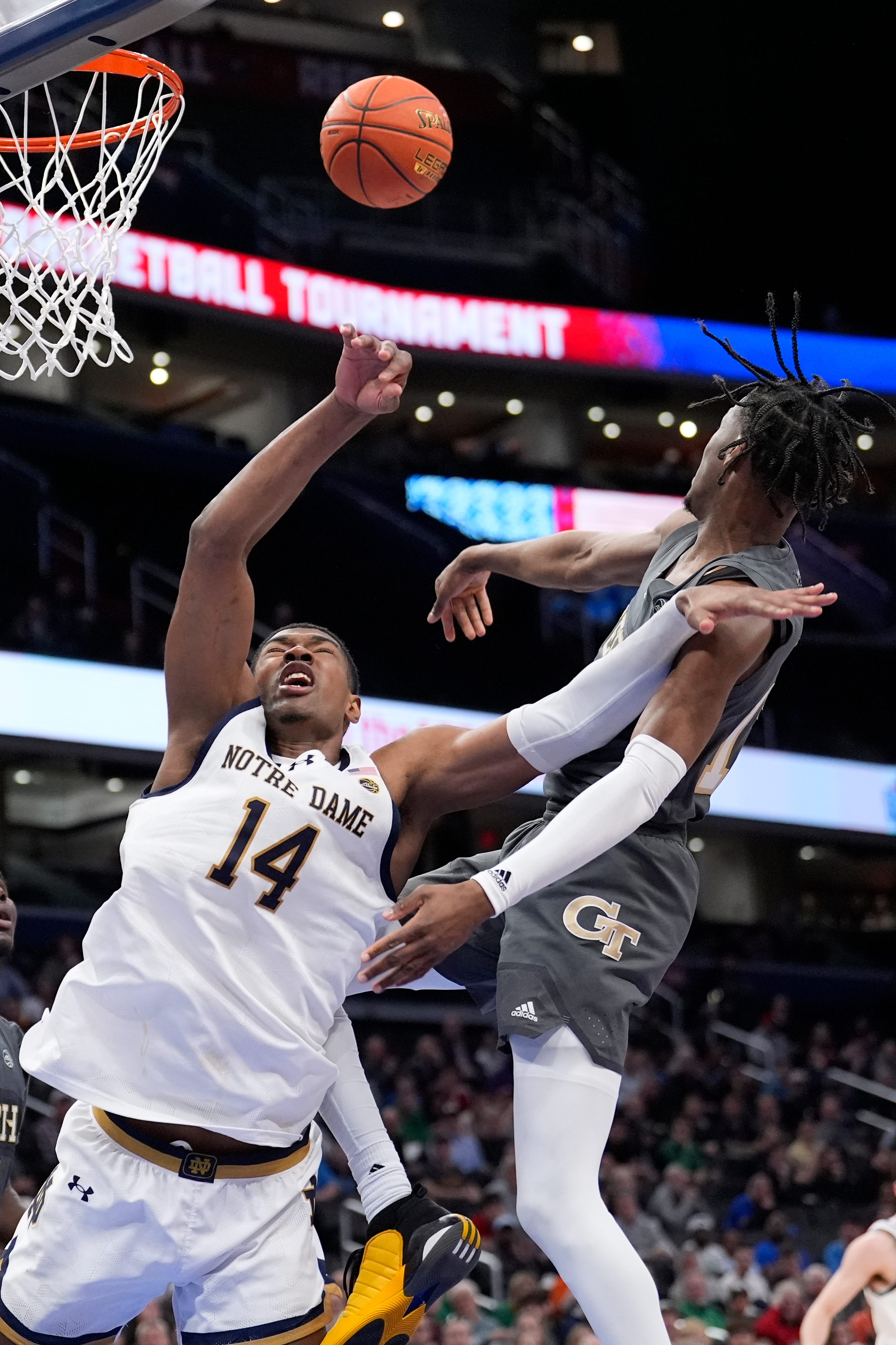 Georgia Tech guard Miles Kelly (13) passes the ball away as he goes up against Notre Dame forward Kebba Njie (14) during the second half of the Atlantic Coast Conference NCAA college basketball tournament, Tuesday, March 12, 2024, in Washington. (AP Photo/Alex Brandon)